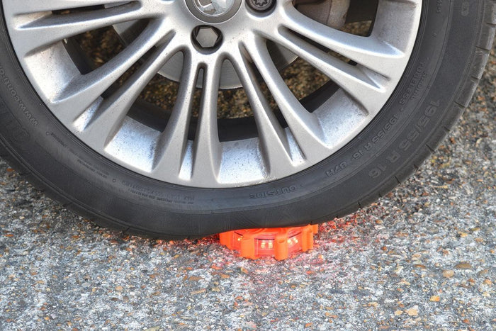 Red Pulsar Pro Rechargeable Hazard Warning Light by NightSearcher in use under car tyre